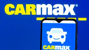 The CarMax logo on a smartphone and in the background