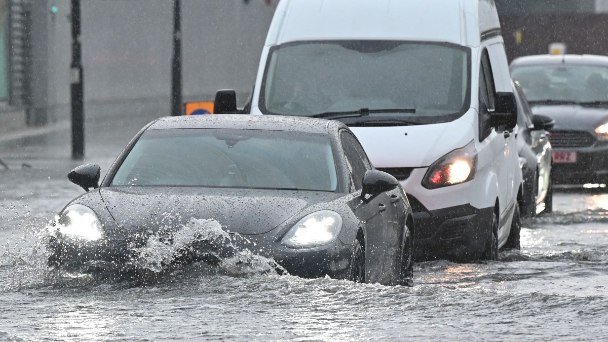 Cars driving through a flooded street, highlighling spring car care tips for safety and reliability