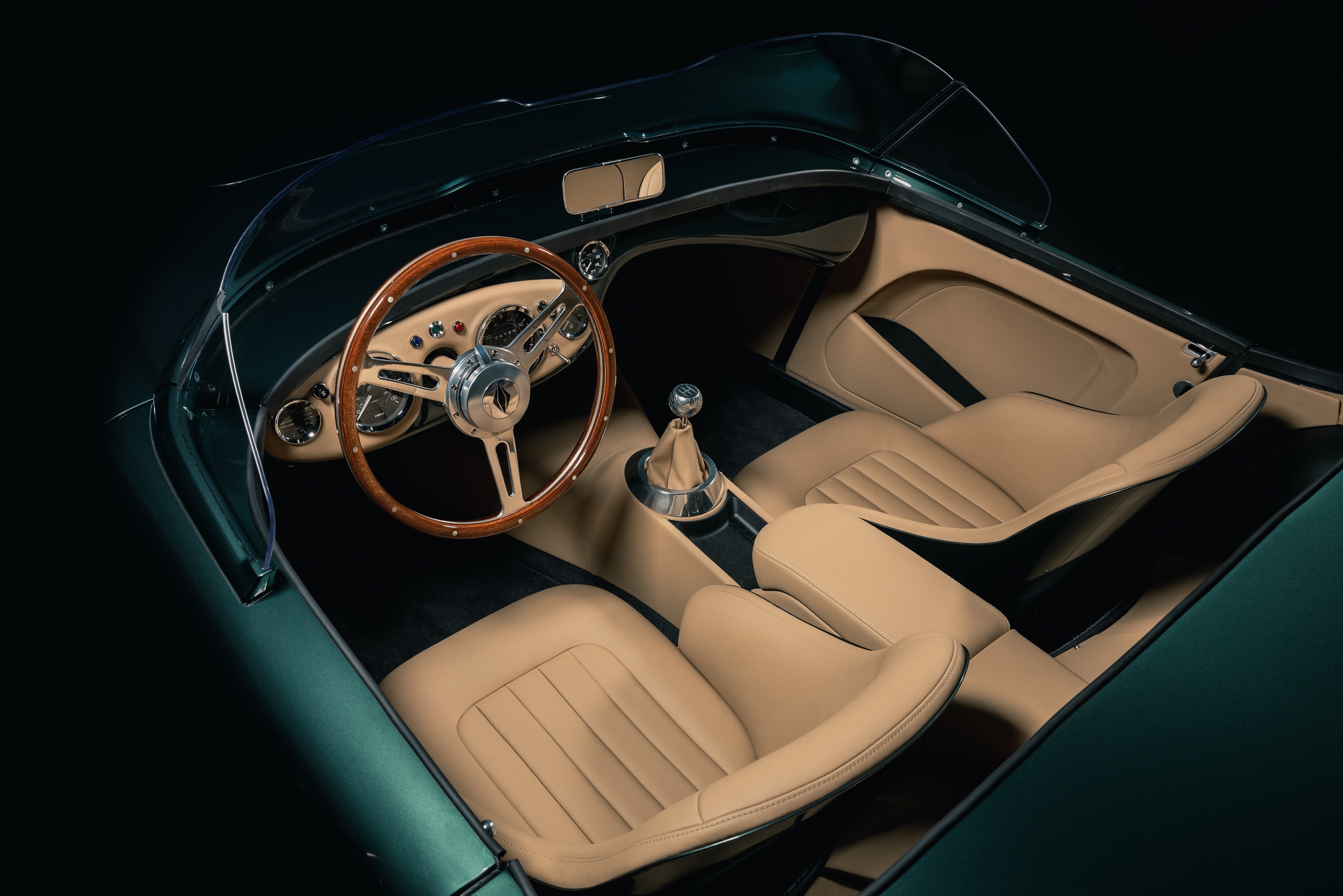 The tan-leather cabin of a dark-green Caton Austin-Healey 100 restomod