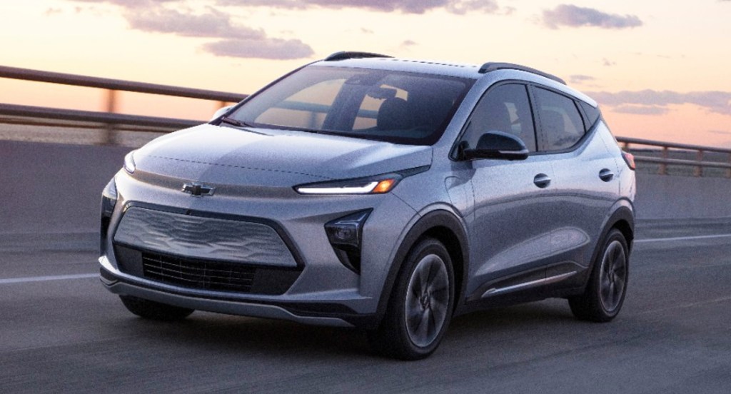 A gray 2022 Chevy Bolt EUV electric SUV is driving on the road. 