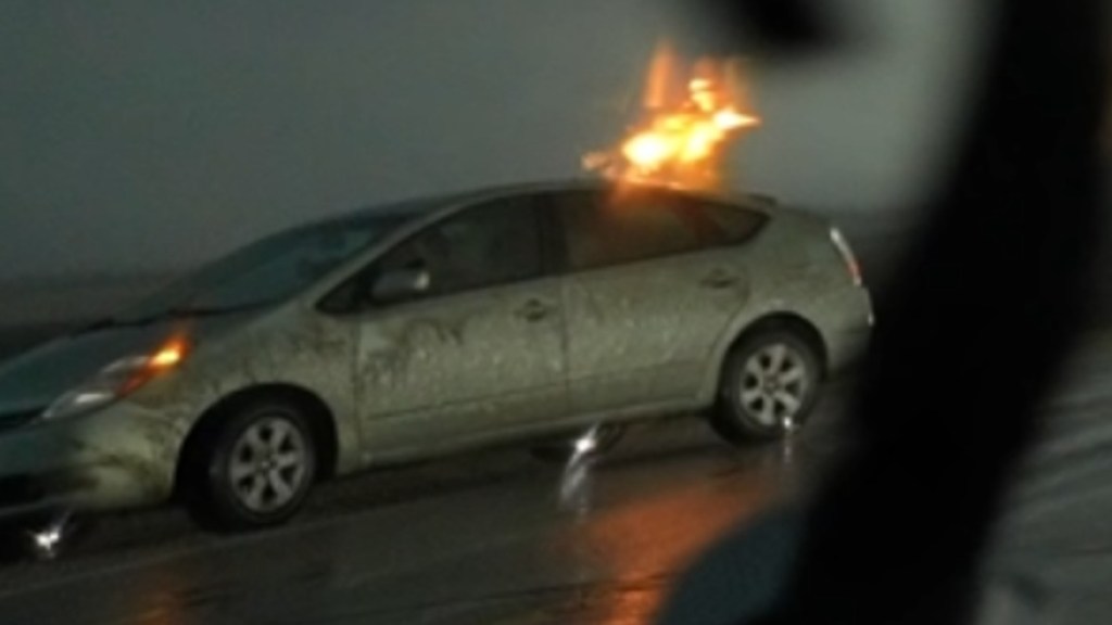 Close-up view of silver Toyota Prius struck by a bolt of lightning