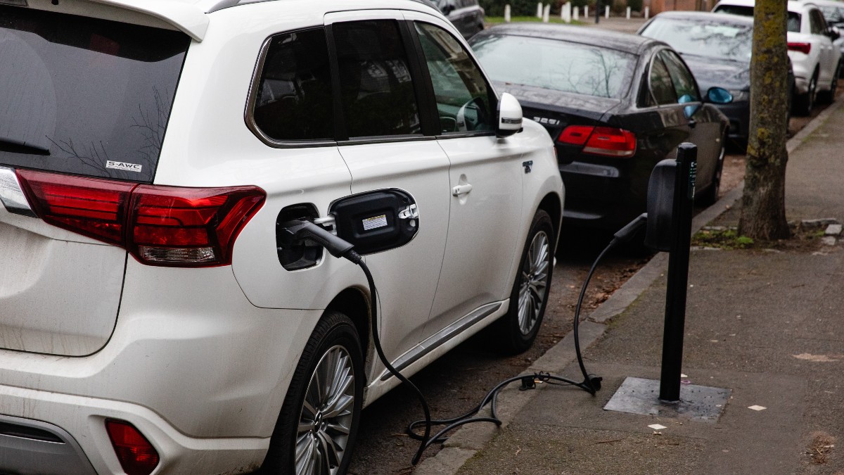 A White car using a Curbside EV Charger. Could this be a home EV charging station?