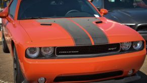 An orange Dodge Challenger with a black stripe down the center.