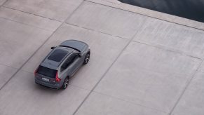 A grey 2022 Volvo XC60 Recharge sits by the water as a PHEV SUV.