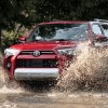 A red 2022 Toyota 4Runner splashing through a puddle.