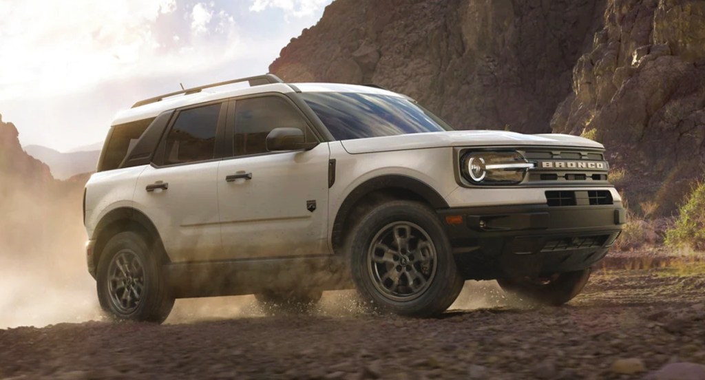 A white 2022 Ford Bronco Sport small SUV model is driving off-road. 