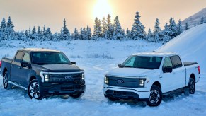 Two Ford F-150 Lightning electric pickup trucks are parked.