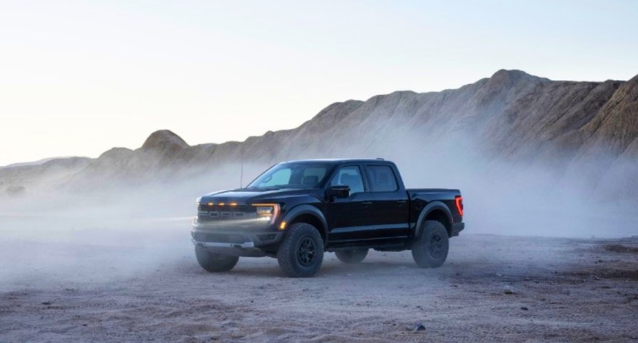 A black 2021 Ford F-150 Raptor off-road performance pickup truck is slower than the Hybrid. 