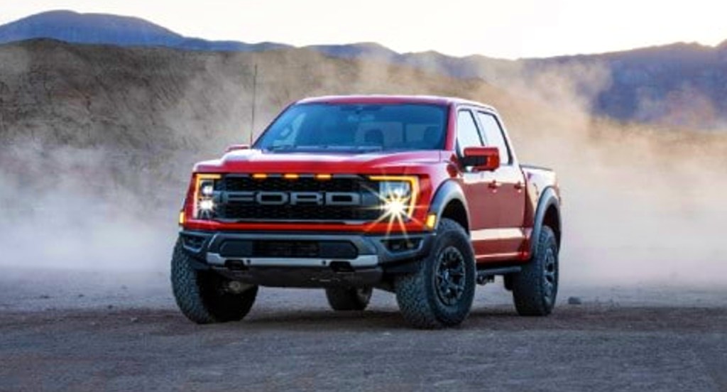 A red 2021 Ford F-150 Raptor off-road pickup truck is parked. 