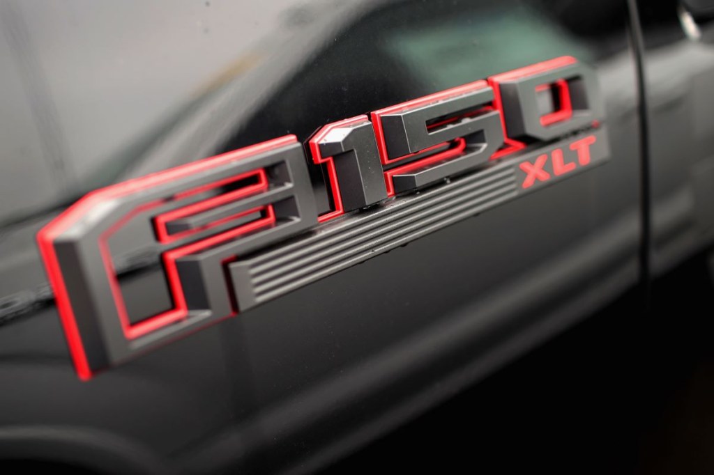 A Ford F-150 logo on a black truck with a red outline.