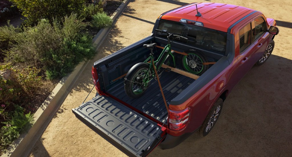 A red 2022 small pickup truck is parked outside.