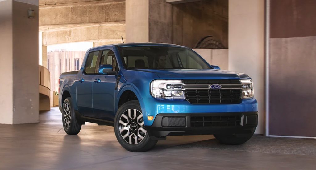 A blue 2022 Ford Maverick small pickup truck is parked indoors. 