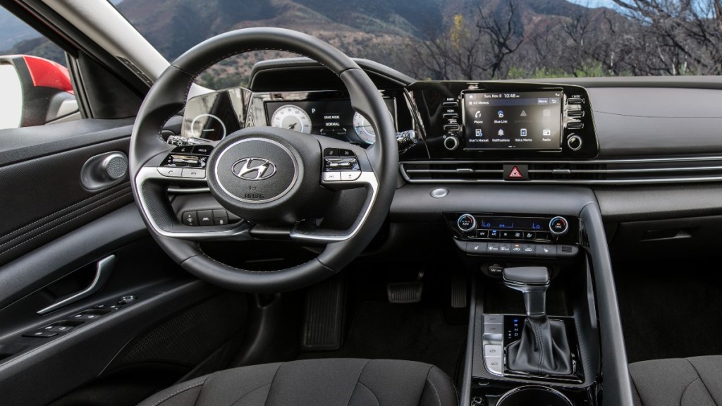 The interior of a 2022 Hyundai Elantra Limited showing off the leather seating, digital gauge cluster, Bose audio system, and dual-zone climate controls