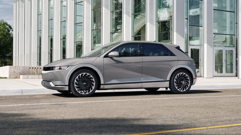 A 2022 Hyundai Ioniq 5 with grey paint sits outside of an urban building.