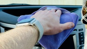 a man wipes down his dashboard using a microfiber towel