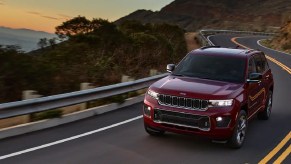 A red 2022 Jeep Grand Cherokee driving around a winding road.