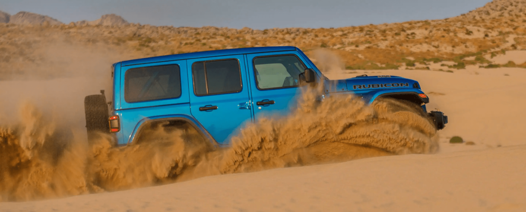 The Jeep Wrangler Rubicon 392 off-road all-terrain SUV driving through sand dunes