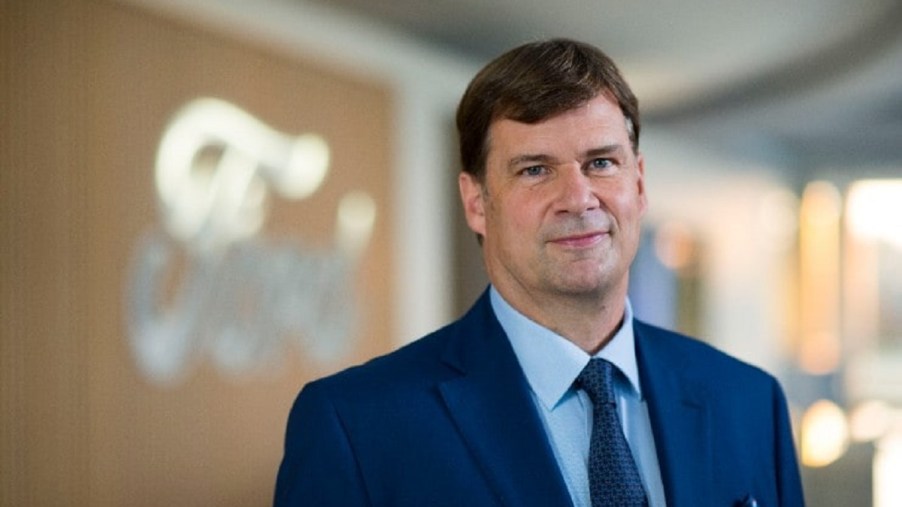 Jim Farley in front of the Ford emblem.