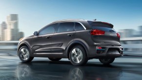 A dark gray 2022 Kia Niro in front of a city.