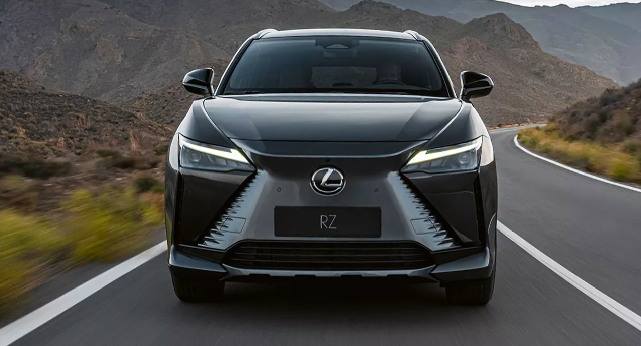 A gray 2023 Lexus 450e electric SUV is driving on the road.