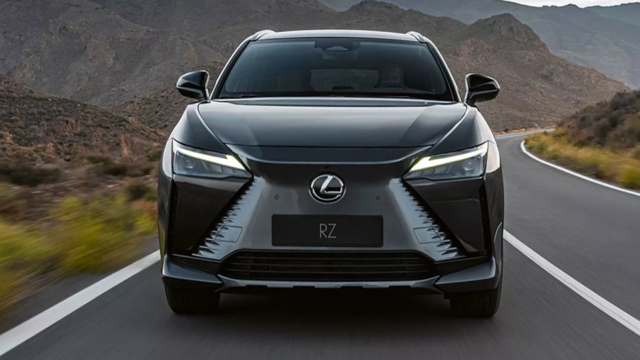 A gray 2023 Lexus 450e electric SUV is driving on the road.