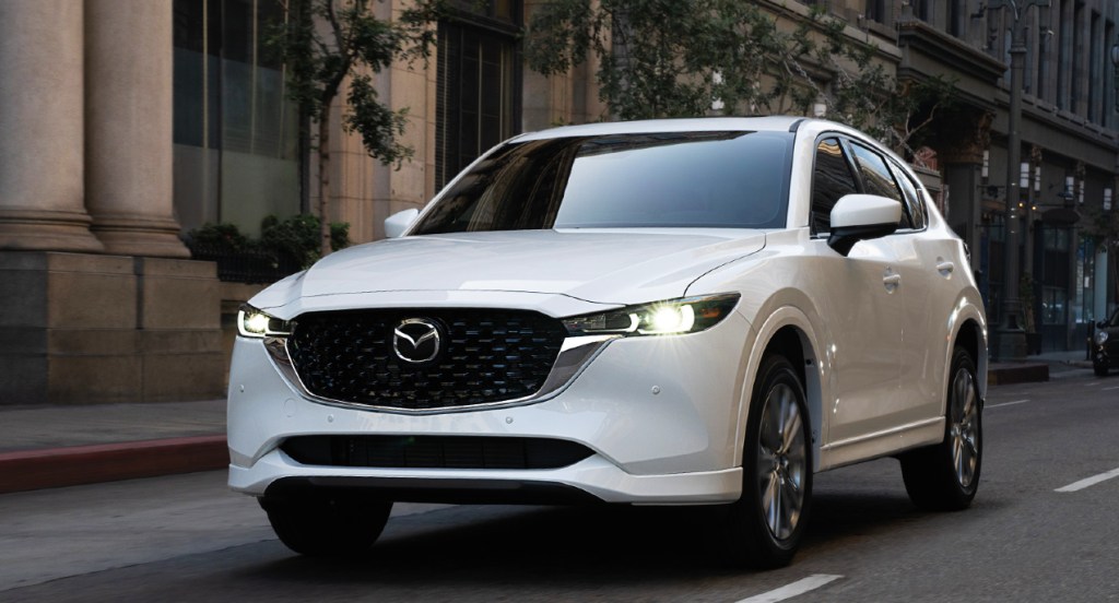 A white 2022 Mazda CX-5 is driving down the road. 