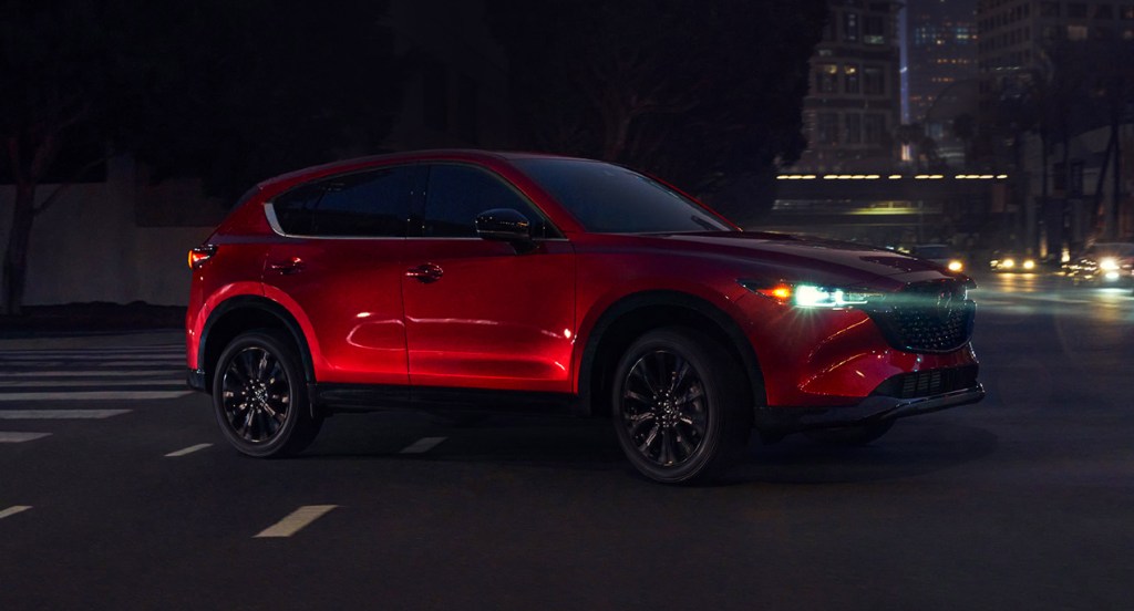 A red 2022 Mazda CX-5 small SUV is driving on the road. 
