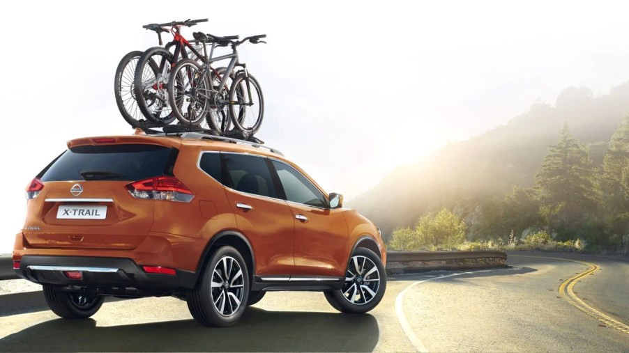 An orange 2022 Nissan X-TRAIL sits on the side of a mountain road as an SUV.