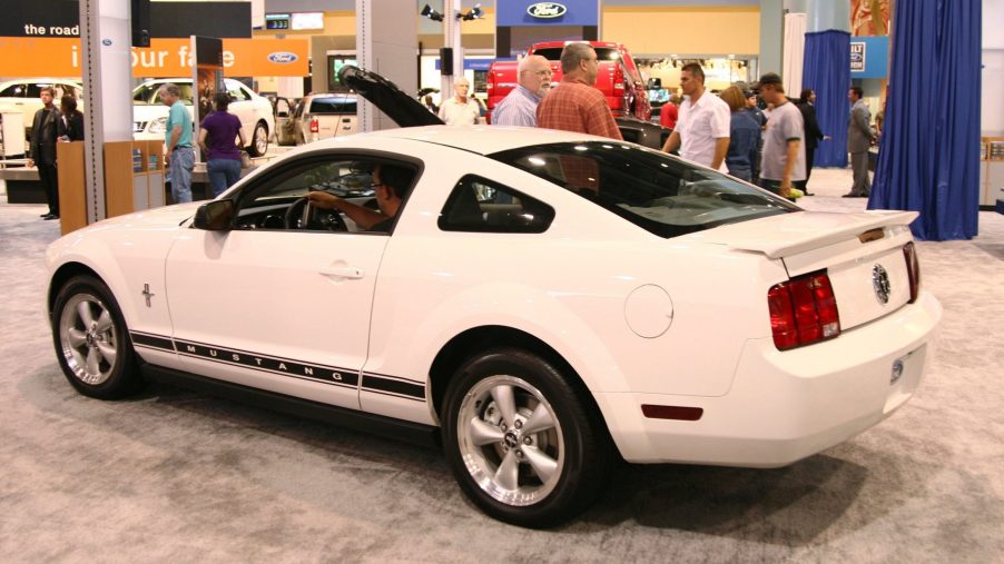 The rear 3/4 view of a white-with-black-stripes 2006 S197 Ford Mustang at the South Florida International Auto Show