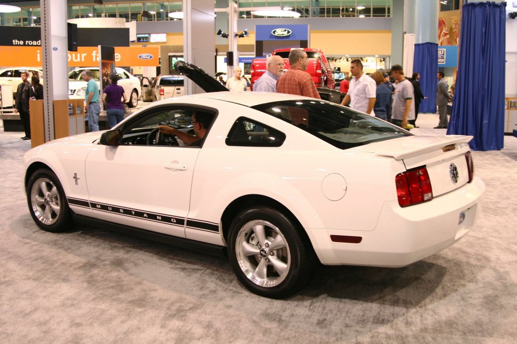 The rear 3/4 view of a white-with-black-stripes 2006 S197 Ford Mustang at the South Florida International Auto Show