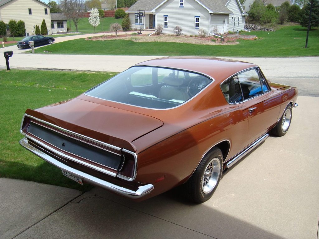 The back deck of a modified 1969 Plymouth Barracuda parked in a driveway.