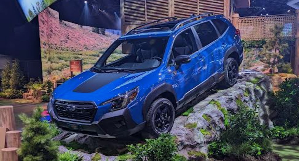 A blue 2022 Subaru Forester Wilderness off-road SUV is on a rock display at the 2022 New York International Auto Show. 