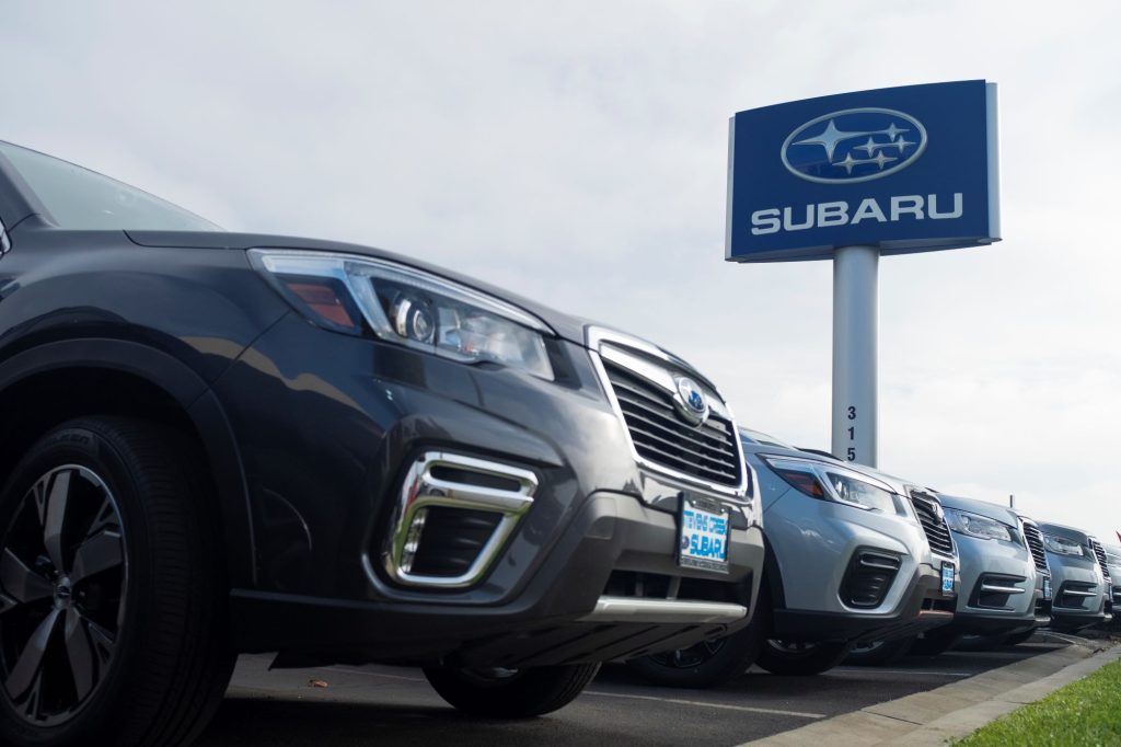 A row of Subaru vehicles with a Subaru sign. 