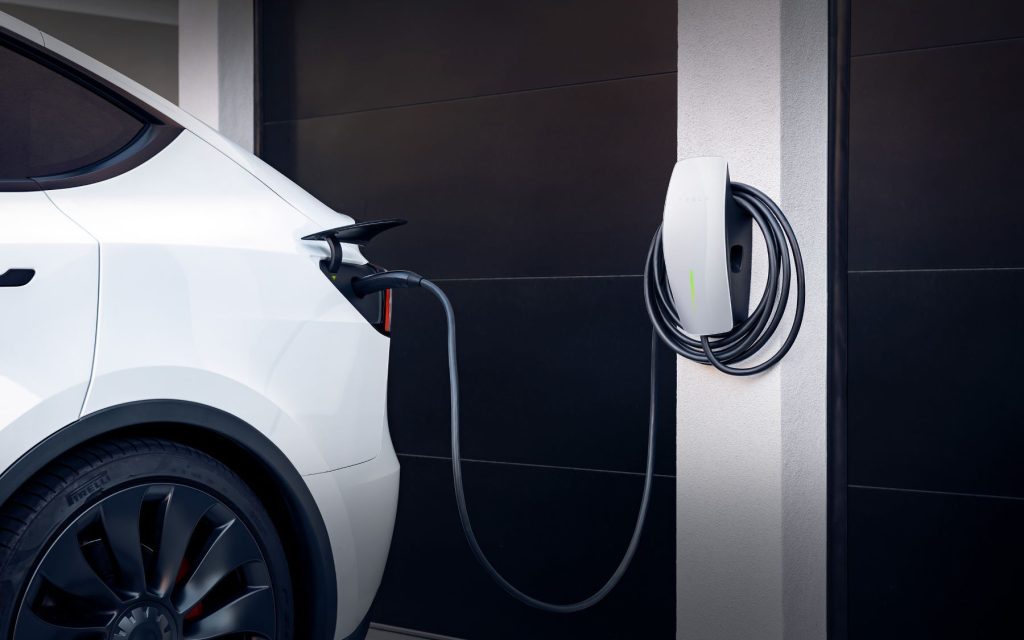 A Tesla Wall Charger plugged into a Tesla model at home - how to turn an electric vehicle into a generator for your home using bidirectional charging technology.
