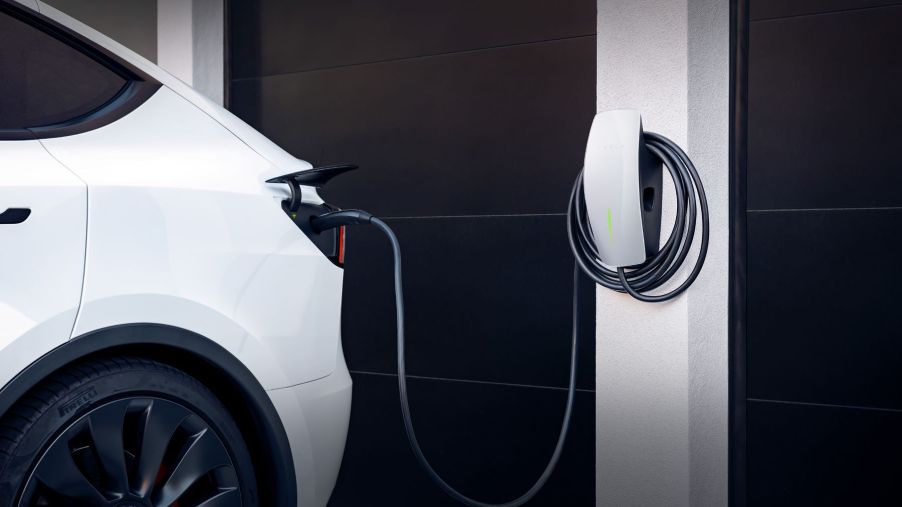 A Tesla Wall Charger plugged into a Tesla model at home