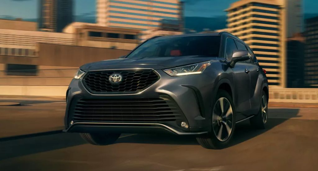 A gray 2022 Toyota Highlander midsize SUV is driving. 