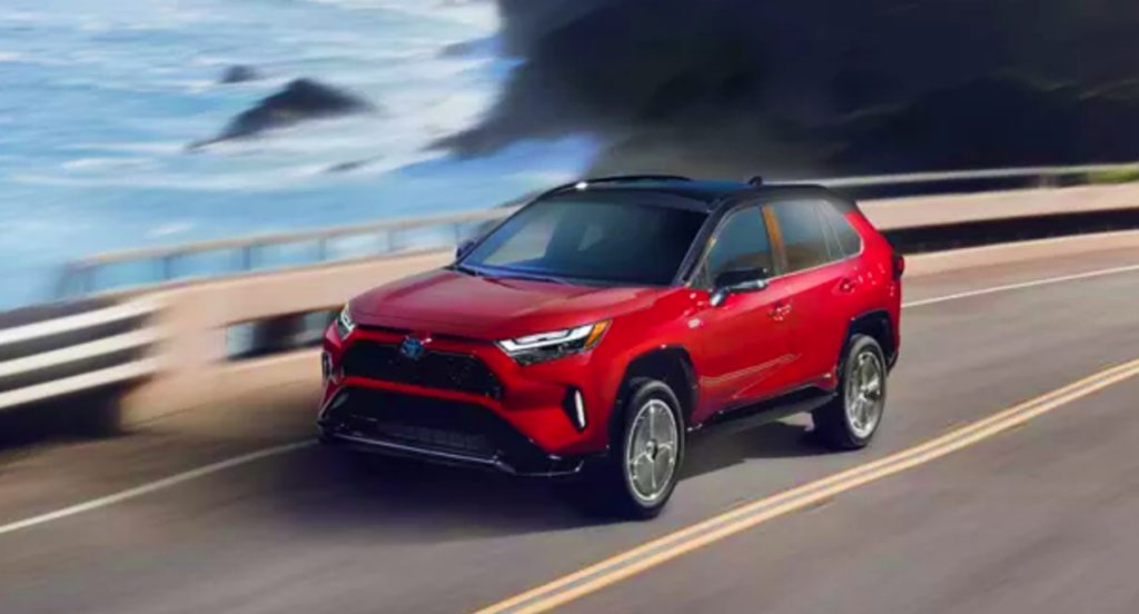 A red 2022 Toyota Rav4 driving along a coast road proves Toyota makes the best Hybrid SUVs - incoming Tacoma PHEV?