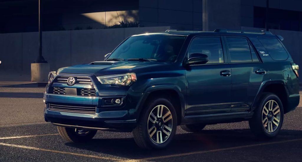A blue 2022 Toyota 4Runner midsize SUV is driving on the road. 