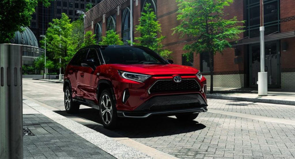 A red Toyota RAV4 Prime plug-in hybrid SUV is parked. It's one of the Toyota SUVs recommended by Consumer Reports