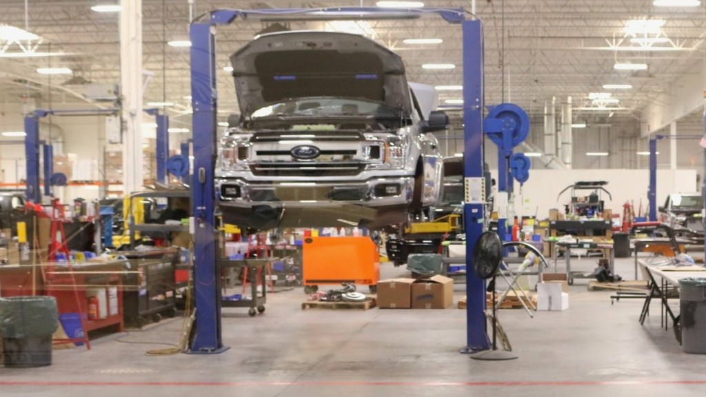 A truck on a lift without any of its wheels during a tire service.