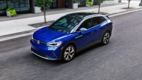 A blue 2022 Volkswagen ID.4 electric SUV is driving on the road.
