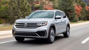 A gray 2022 Volkswagen Atlas midsize three-row SUV is driving on the road.
