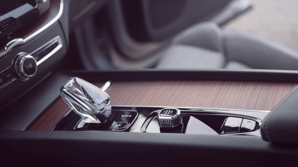 The interior of the Volvo XC60 Recharge shows off a crystal shift knob and wood trim, true marks of a luxury SUV.