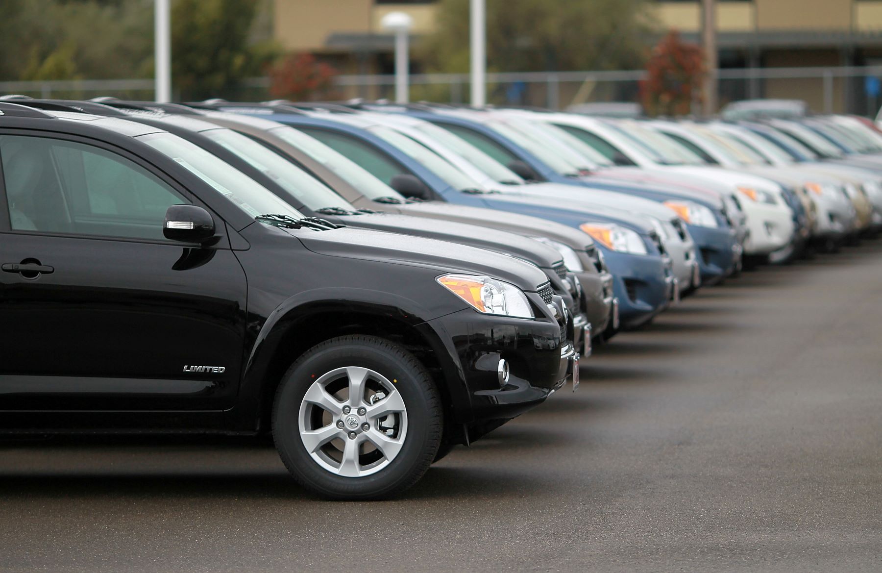 A lineup of Toyota RAV4 SUV models at a Toyota dealership in Oakland, California