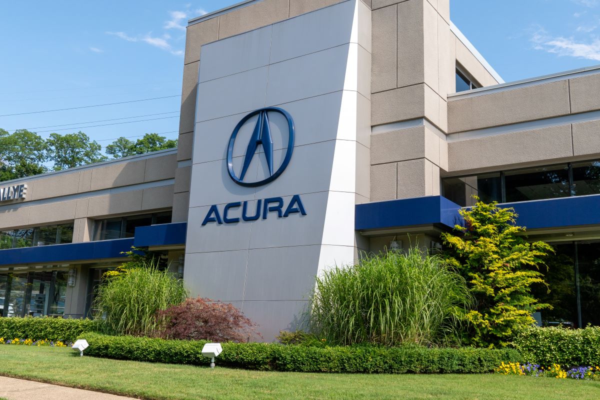 Exterior shot of an Acura dealership on a bright sunny day. Dealers sell both new and used Acura cars