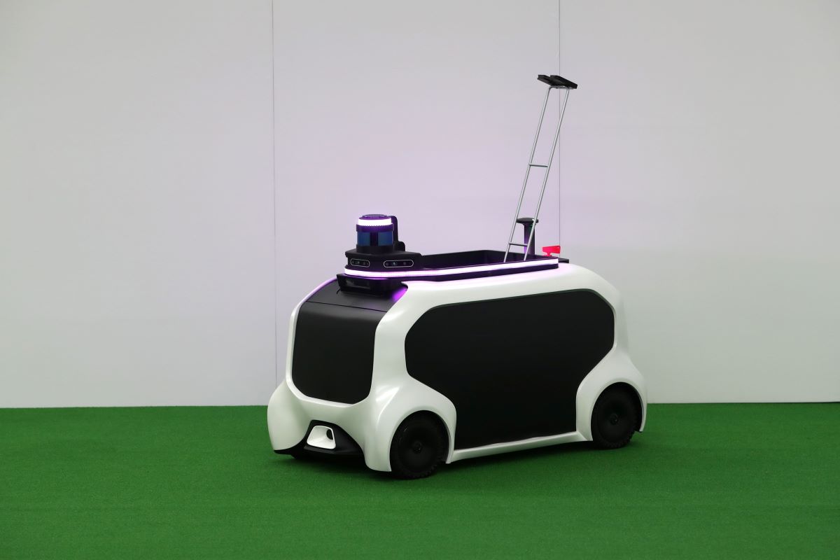 A black-and-white autonomous robot with wheels, shaped like a rolling wagon, used at the 2020 Paralympic games to assist with tasks