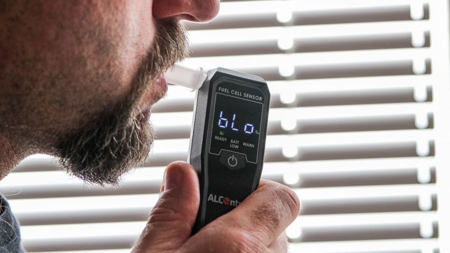 A man suspected of drinking and driving takes a breathalyzer test