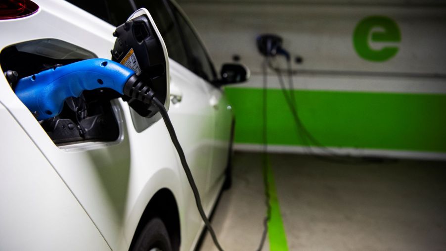 A Toyota vehicle connected to an electric vehicle charging station, which is one of the best EV accessories to have