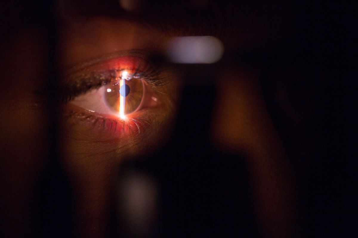 A laser scanning a woman's eye in the dark