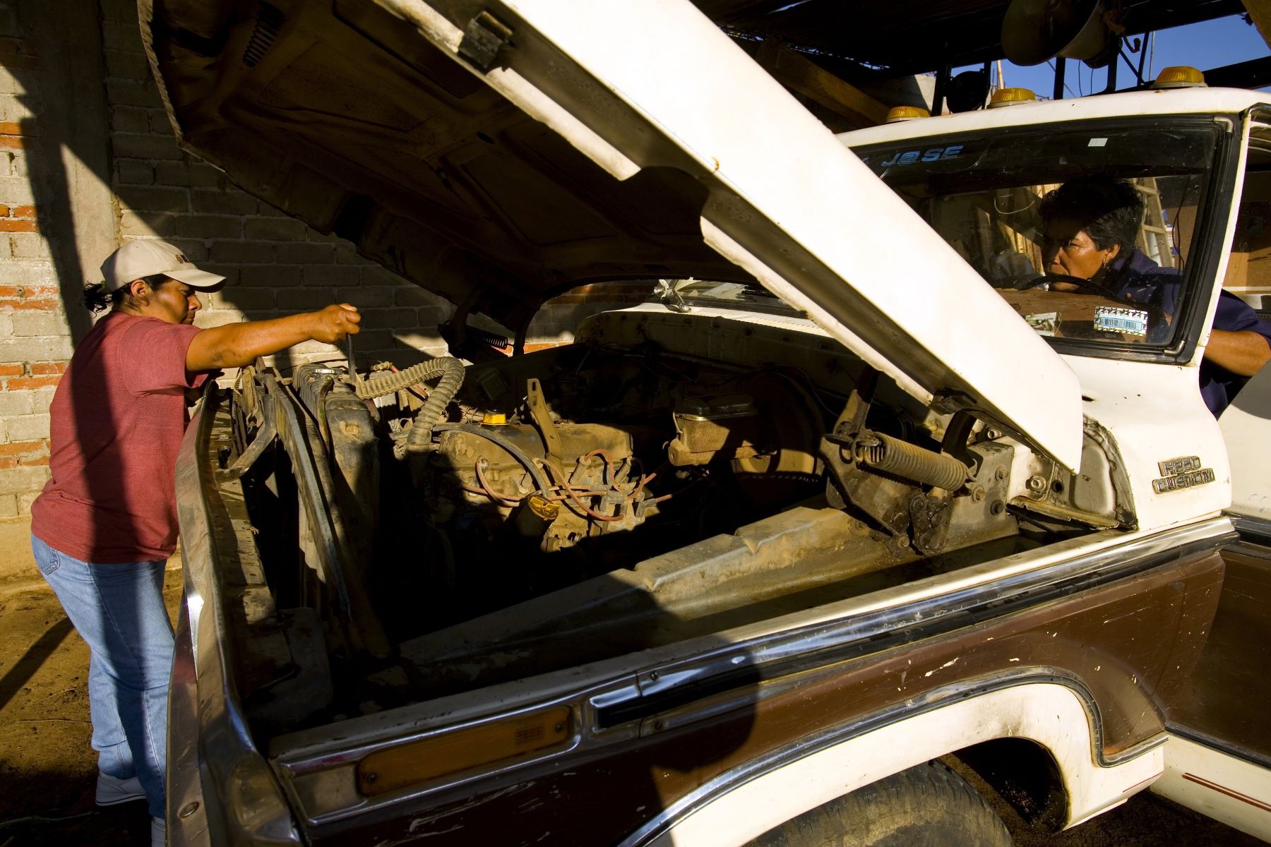 An oil change being performed on a truck in Oaxaca, Mexico
